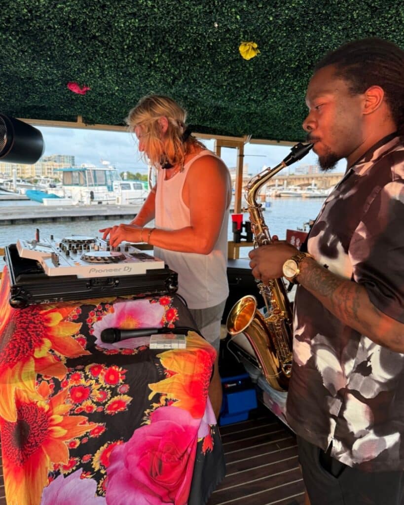 Live DJ and saxophone musician performing during a special event cruise on the Friki Tiki in Charleston.