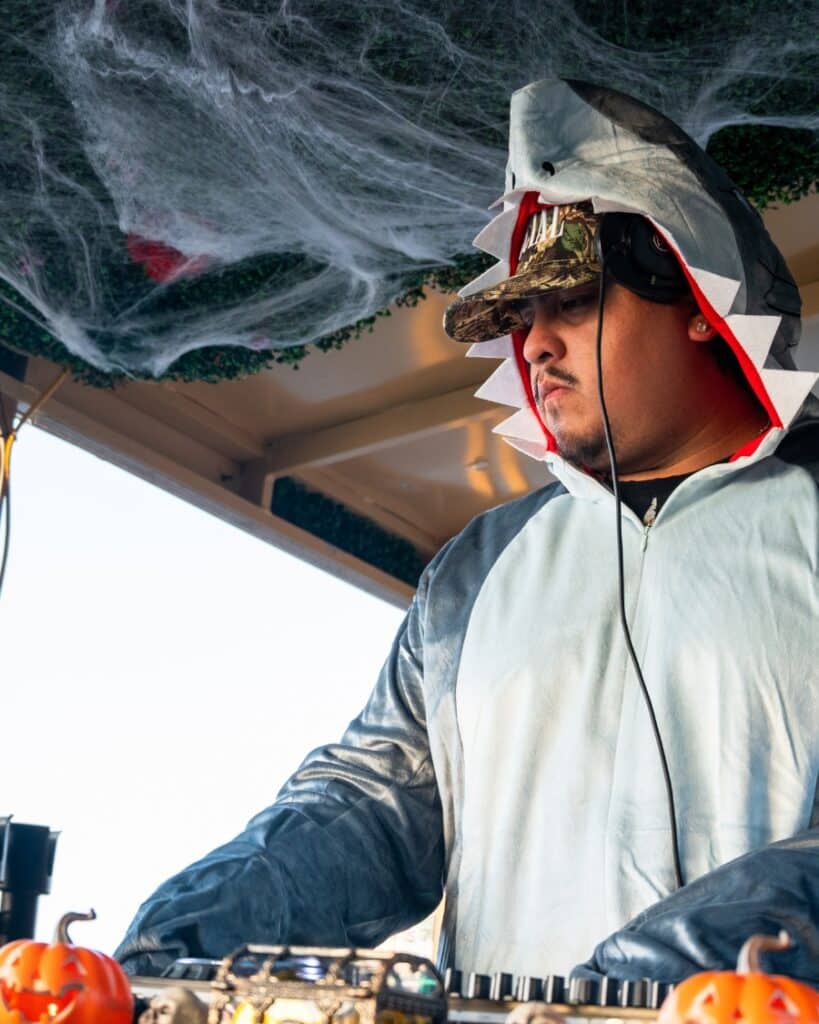 DJ dressed in a shark costume performing on a Halloween boat party in Charleston.