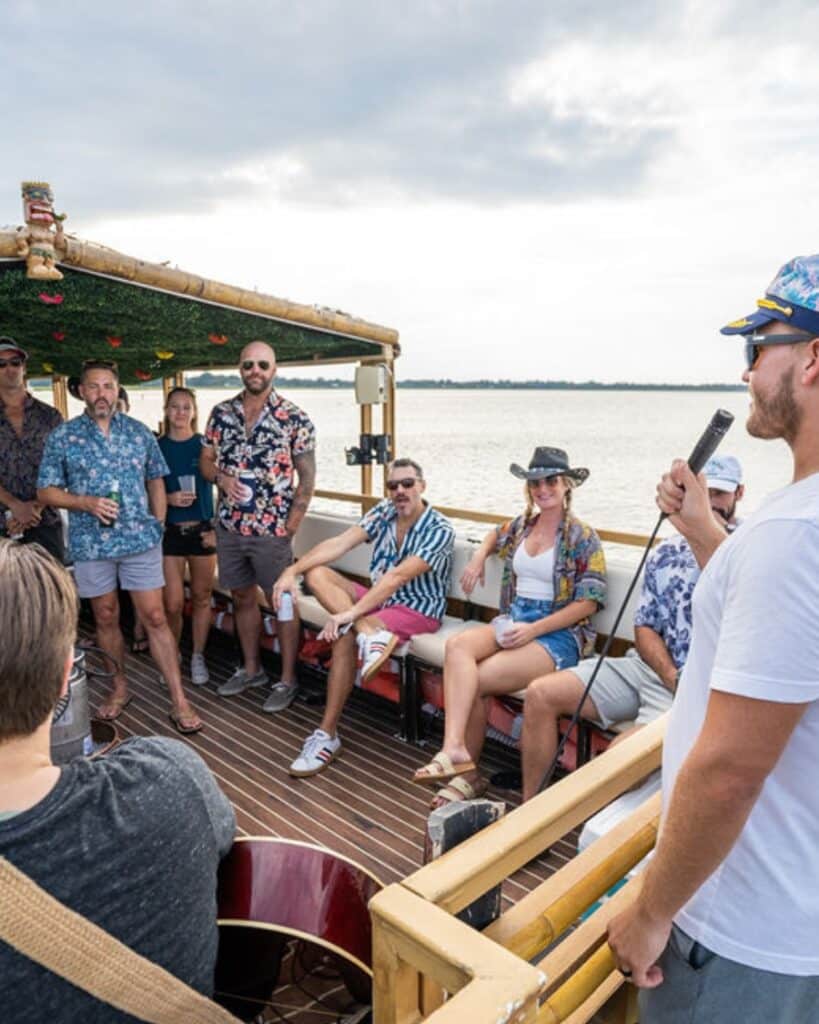 Group of adults enjoying a live music performance aboard the Friki Tiki during a special event cruise in Charleston.