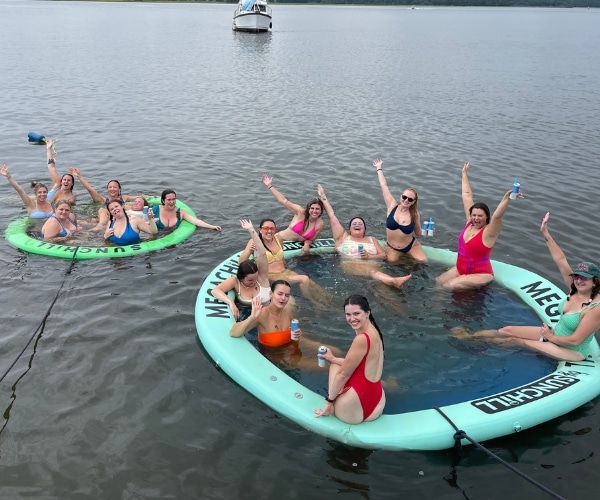 Guests relaxing and mingling on a semi-private tiki cruise in Charleston, enjoying drinks and floats.