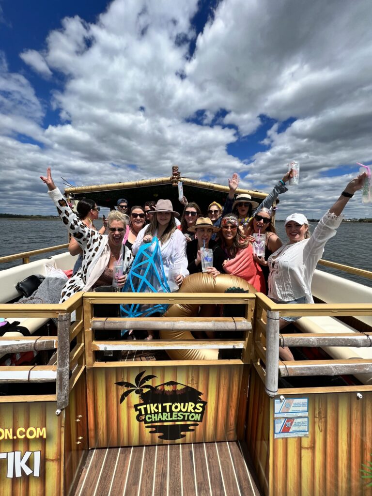 IMG 3220-scaled A large group of professionals and friends posing for a group photo on the spacious deck of the Friki Tiki party boat in Charleston Harbor.