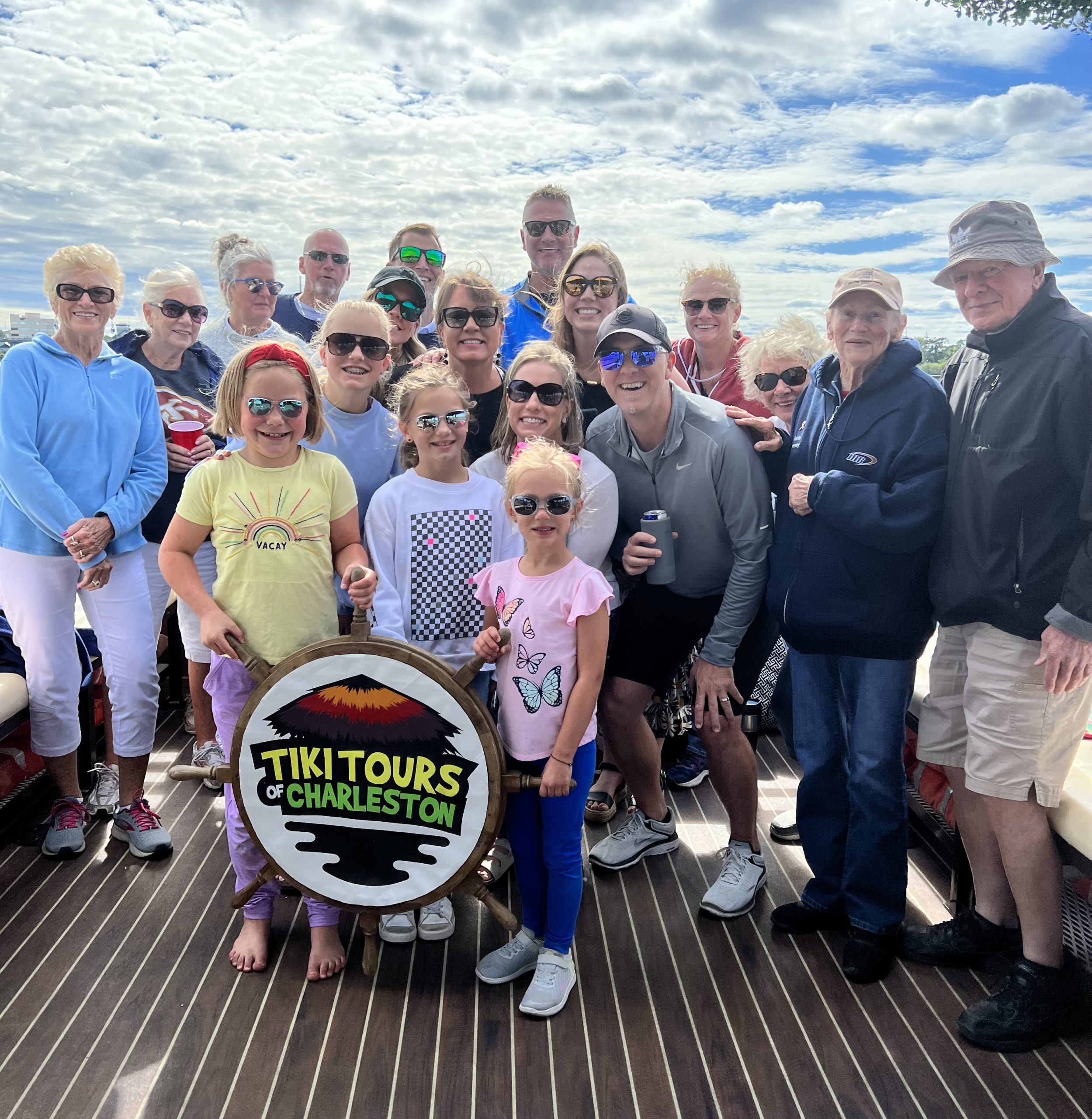 A happy guest cheering and enjoying a drink on the Friki Tiki party boat in Charleston, SC.