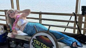 A group of people enjoying a well-coordinated and successful Charleston boat party on the Friki Tiki, featuring group celebrations and harbor views.