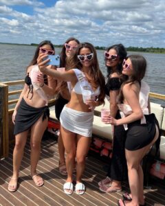 A bride-to-be and her bridesmaids celebrating with drinks on the Friki Tiki bachelorette boat in Charleston.