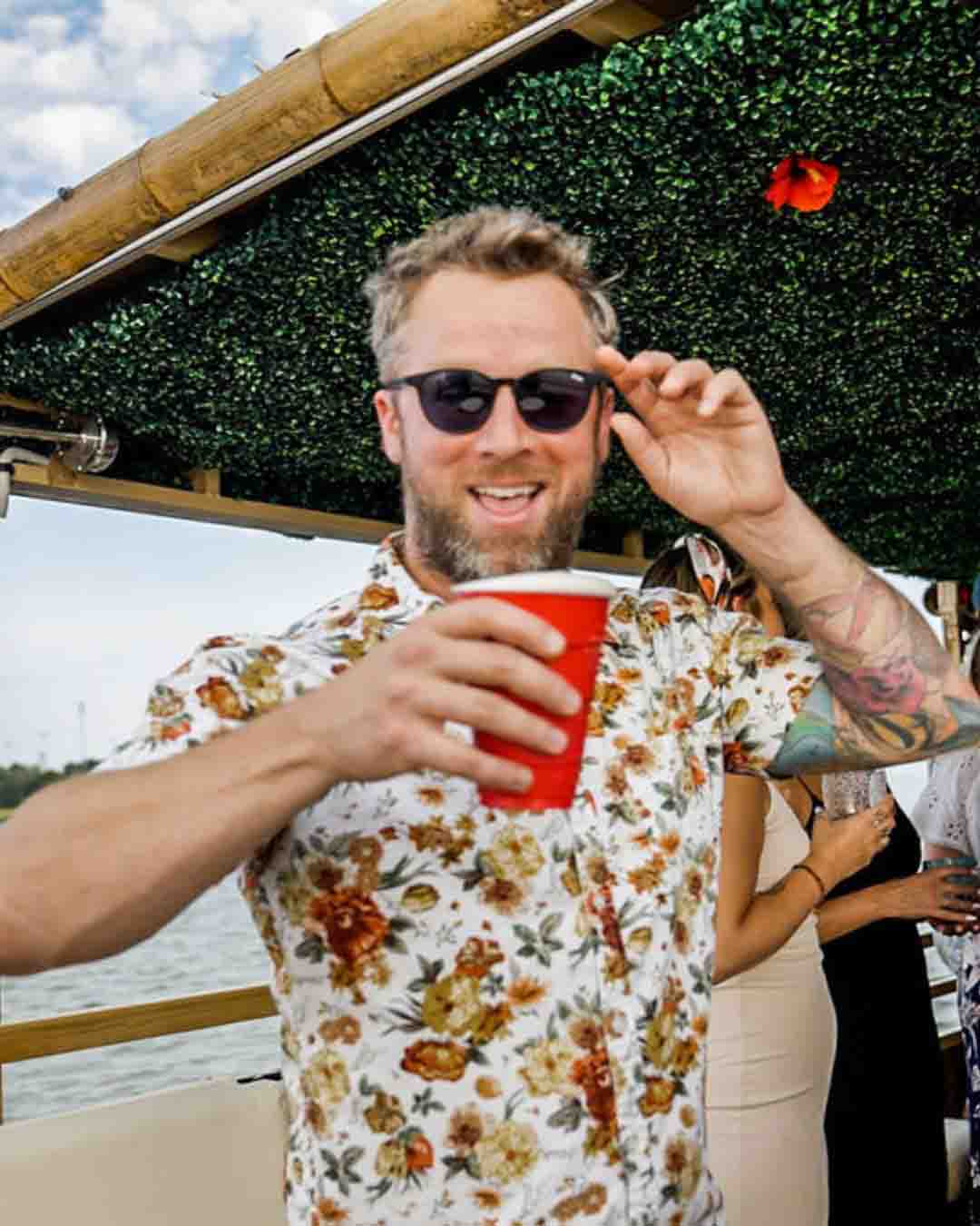 Why Rent a Party Boat in Charleston with Tiki Tours A large group of friends cheering on the bow of the Friki Tiki party boat during a group cruise in Charleston Harbor.